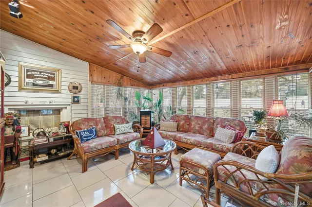 a living room with furniture a ceiling fan and a large window
