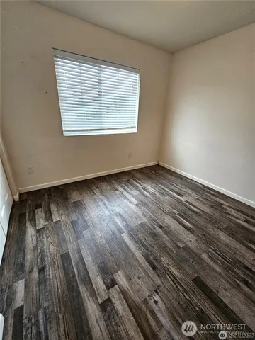 a view of a livingroom with a chandelier fan and wooden floor