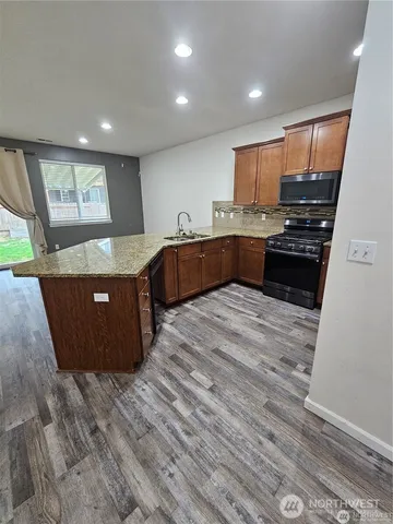 a large kitchen with kitchen island a sink stainless steel appliances and cabinets