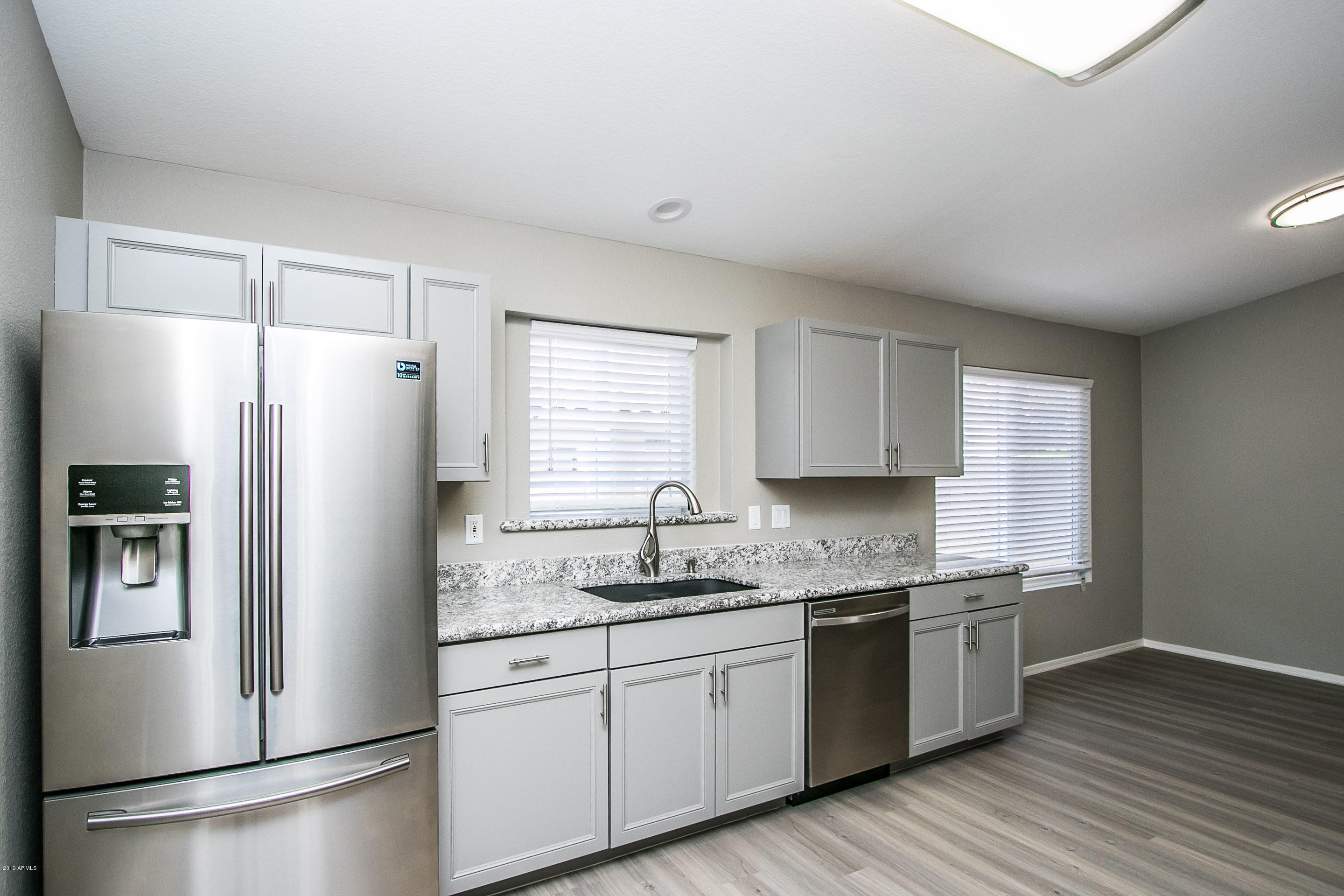 3948 East Stanford Avenue Gilbert, AZ 85234 - Photo 12 of 32 a kitchen with a refrigerator a sink and wooden floor