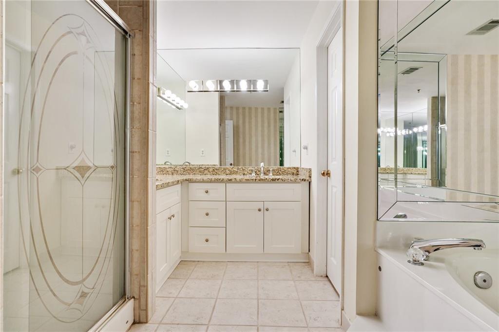 3203 Lenox Road Northeast, Unit 6 Atlanta, GA 30324 - Photo 13 of 27 a bathroom with a granite countertop sink a mirror and a bathtub