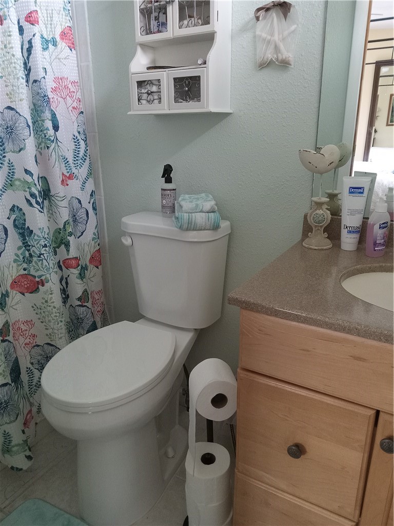 740 Lark Drive Sebastian, FL 32976 - Photo 8 of 11 a white toilet sitting next to a bathroom sink