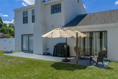 a view of backyard with a table and chairs under an umbrella