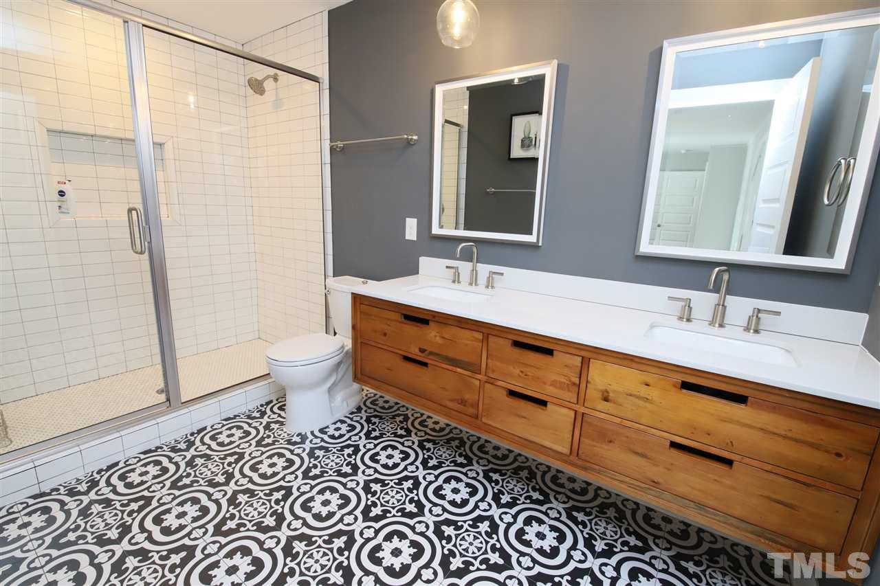 1308 East Lane Street Raleigh, NC 27610 - Photo 16 of 21 a bathroom with a double vanity sink toilet mirror and shower