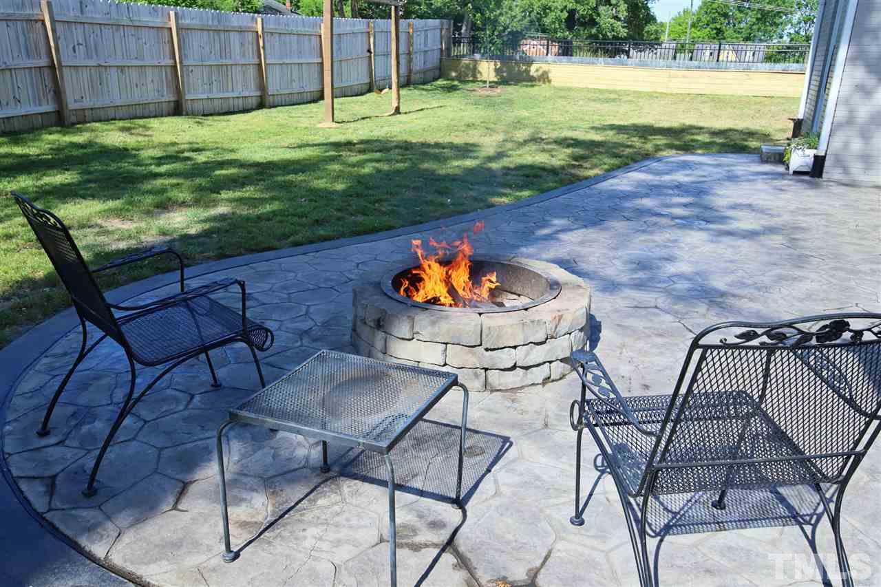1308 East Lane Street Raleigh, NC 27610 - Photo 3 of 21 a view of a backyard with a table and chairs with wooden floor and fence