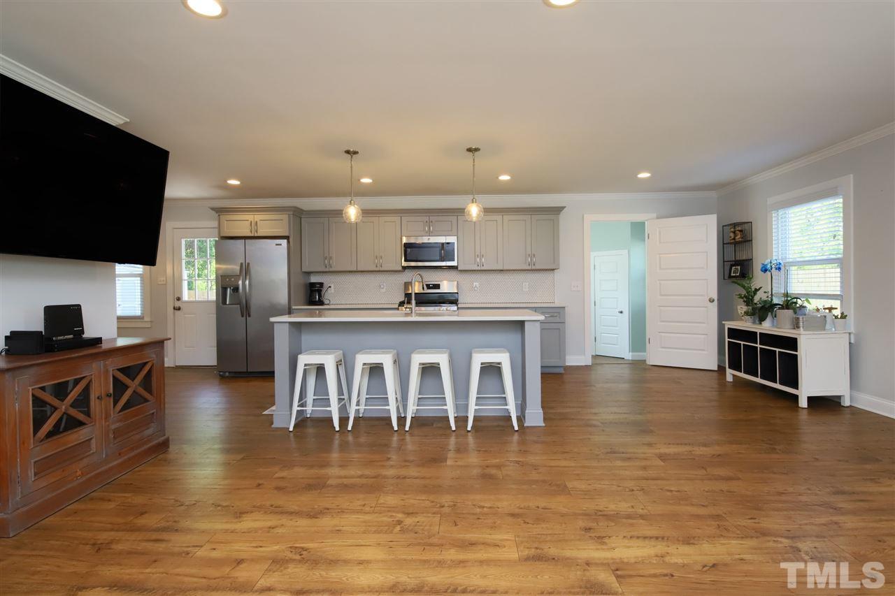 1308 East Lane Street Raleigh, NC 27610 - Photo 5 of 21 a kitchen with stainless steel appliances granite countertop a stove top oven a sink a counter space and cabinets