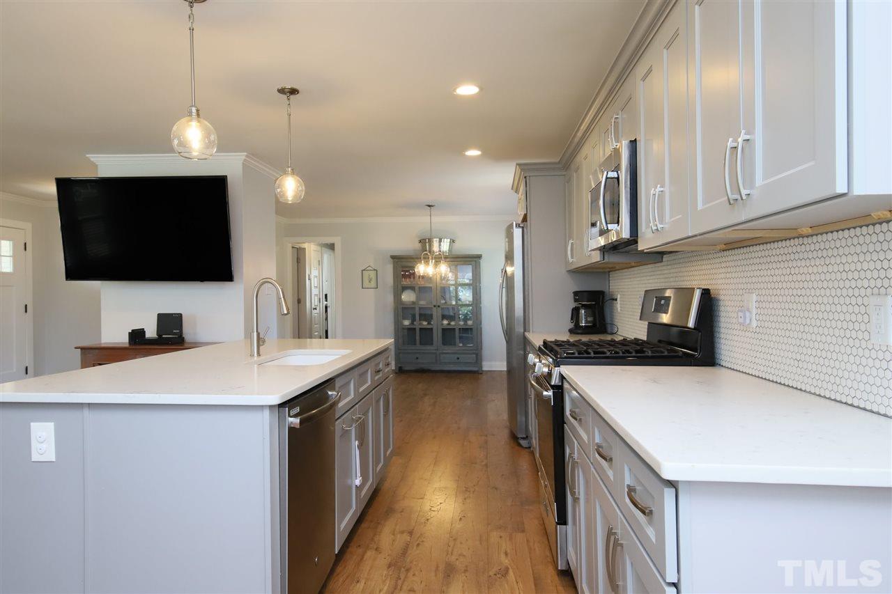 1308 East Lane Street Raleigh, NC 27610 - Photo 6 of 21 a kitchen with stainless steel appliances granite countertop a sink a stove and a refrigerator