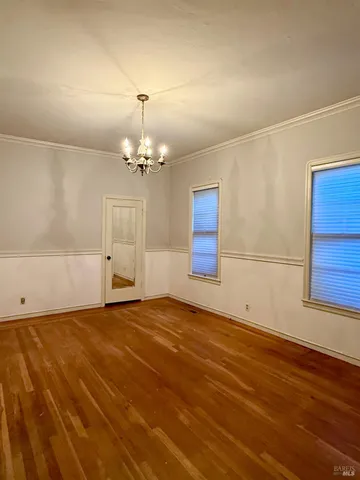 a view of empty room with wooden floor and fireplace