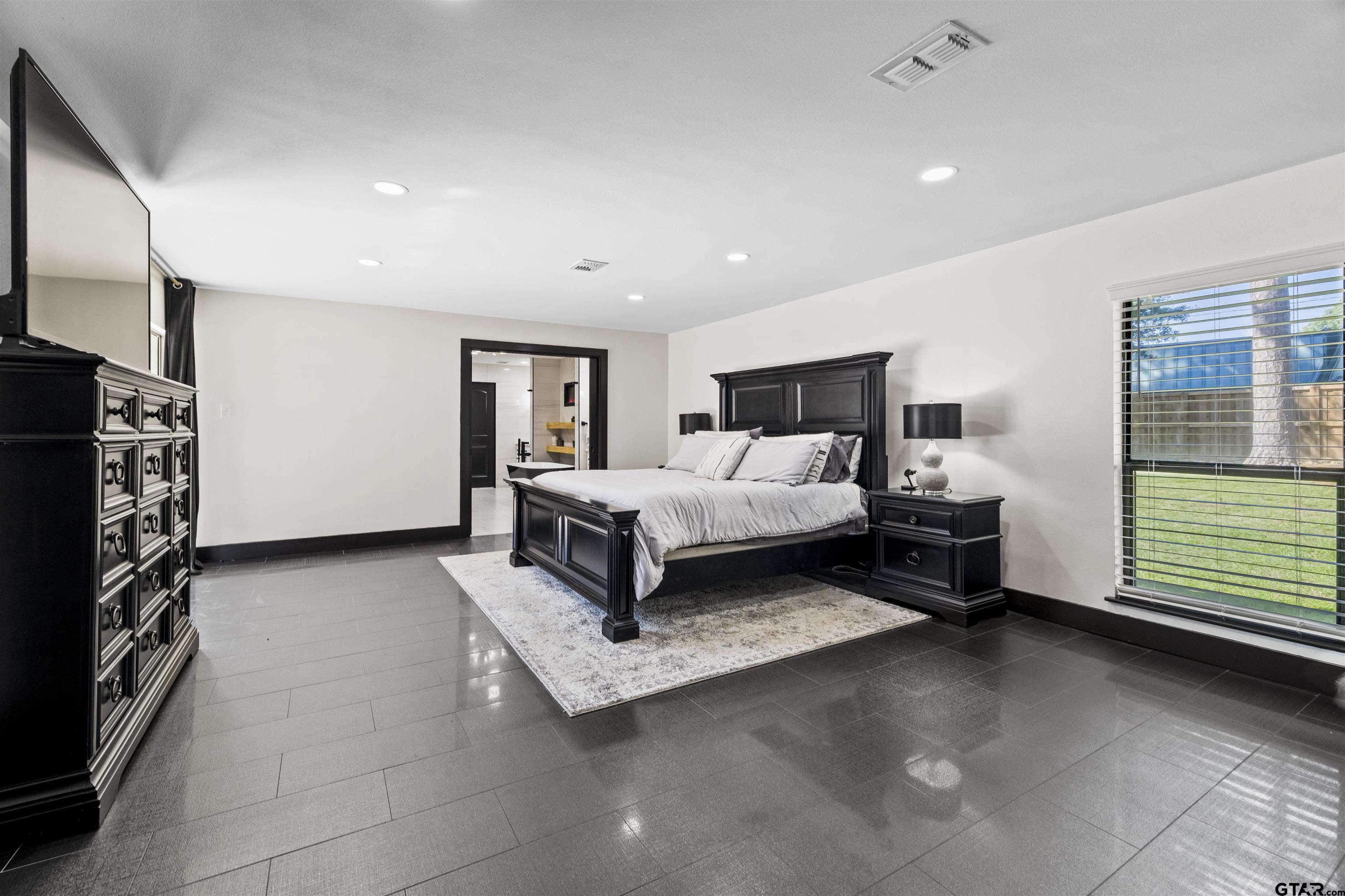 1300 Montclair Street Longview, TX 75601 - Photo 15 of 40 a spacious bedroom with a bed and a couch