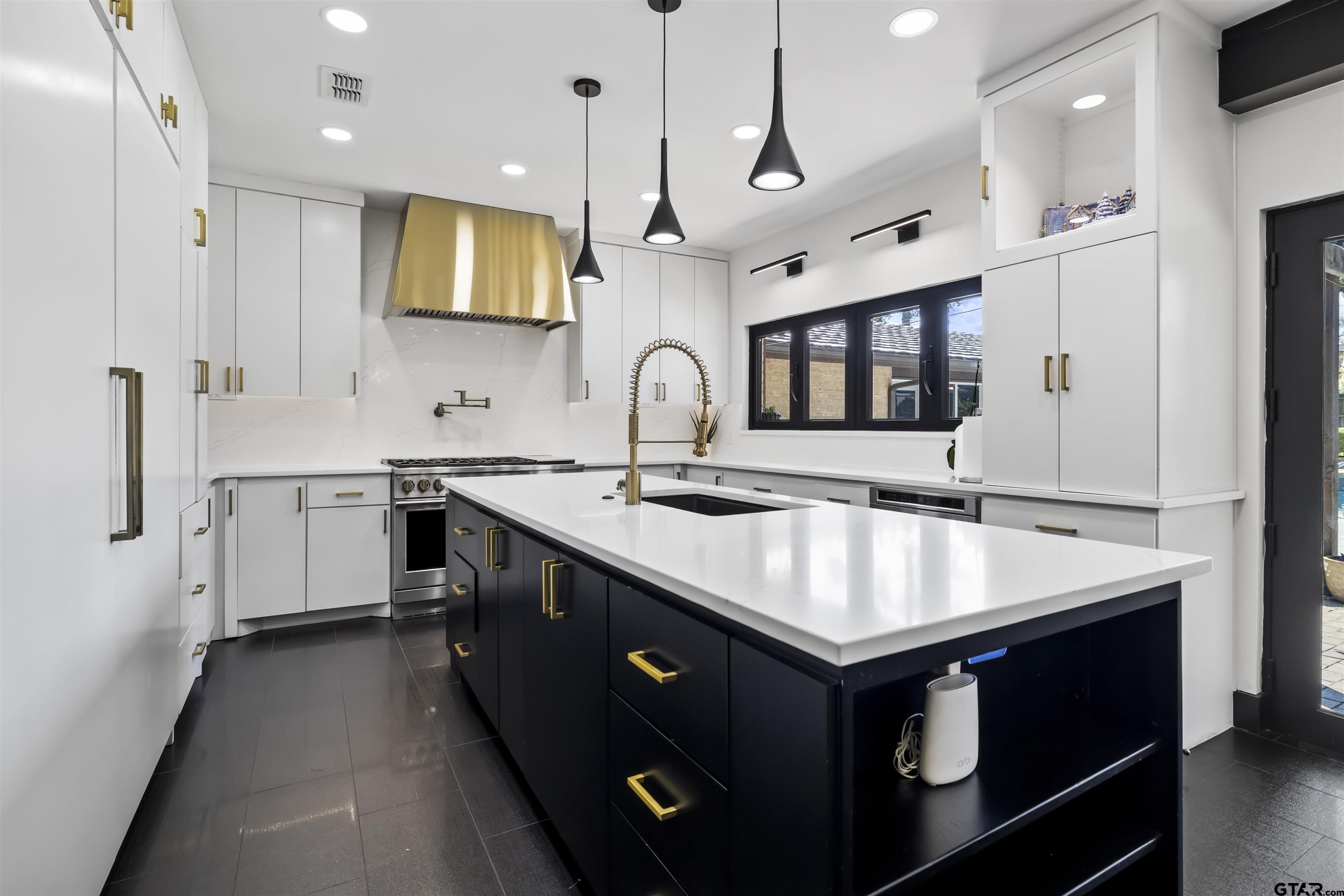 1300 Montclair Street Longview, TX 75601 - Photo 8 of 40 a kitchen that has a sink a microwave oven a stove and a dining table with wooden floor