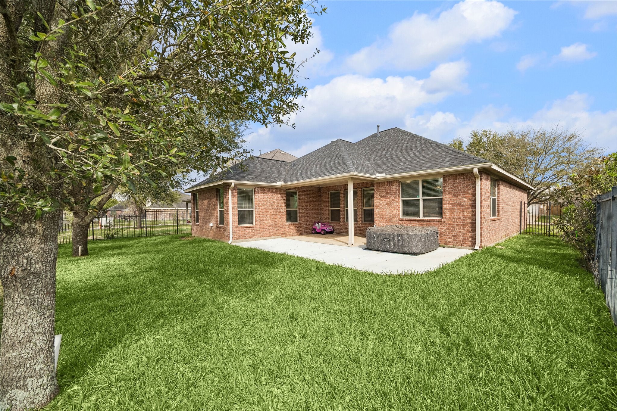 7806 Summer Night Lane Rosenberg, TX 77469 - Photo 22 of 23 The backyard includes a covered patio overlooking a spacious lawn, offering room for outdoor seating and activities.
