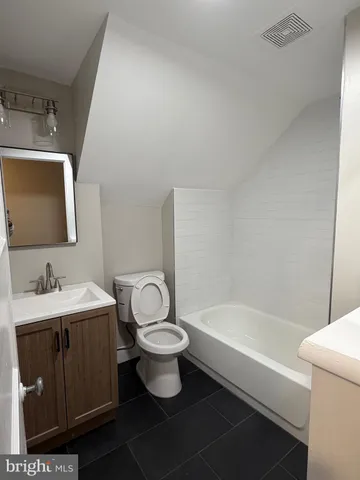 a bathroom with a sink toilet a mirror and bathtub
