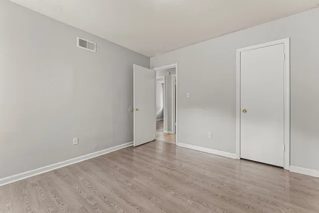a view of an empty room with wooden floor