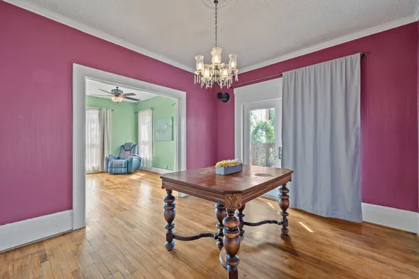 a view of a hallway to room with a ceiling fan