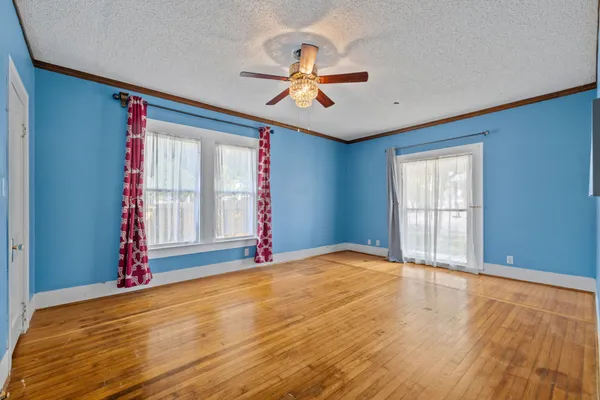 a view of room with wooden floor and ceiling fan