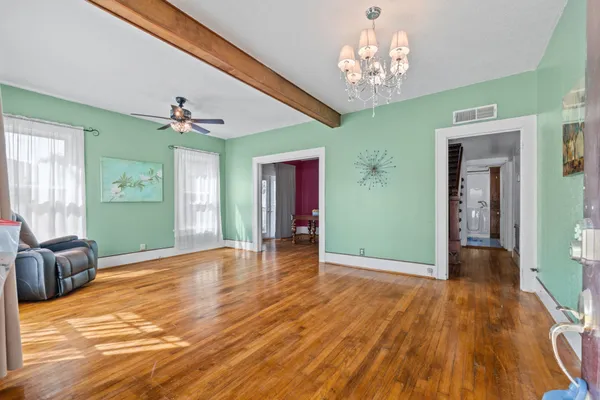 a view of a livingroom with wooden floor and a large window