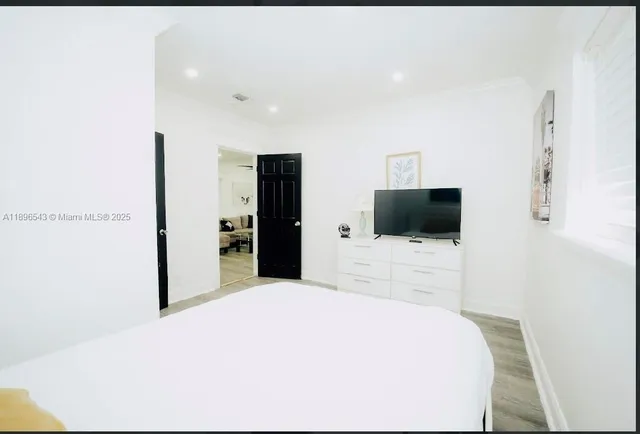 a bedroom with a bed and a flat screen tv