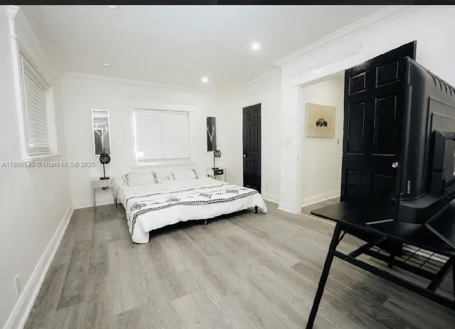 a bedroom with a bed and wooden floor