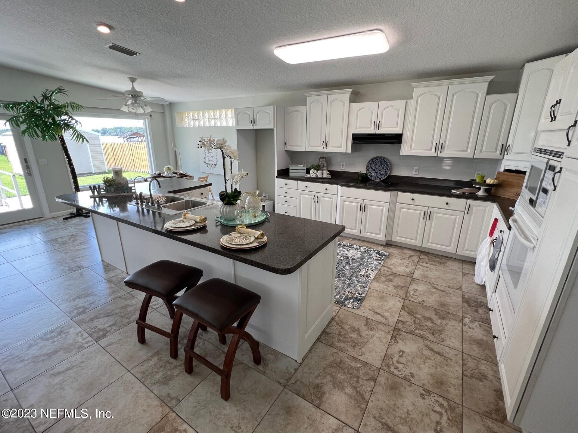 2976 Magnolia Road Orange Park, FL 32065 - Photo 13 of 44 a kitchen with stainless steel appliances granite countertop a table chairs sink and cabinets