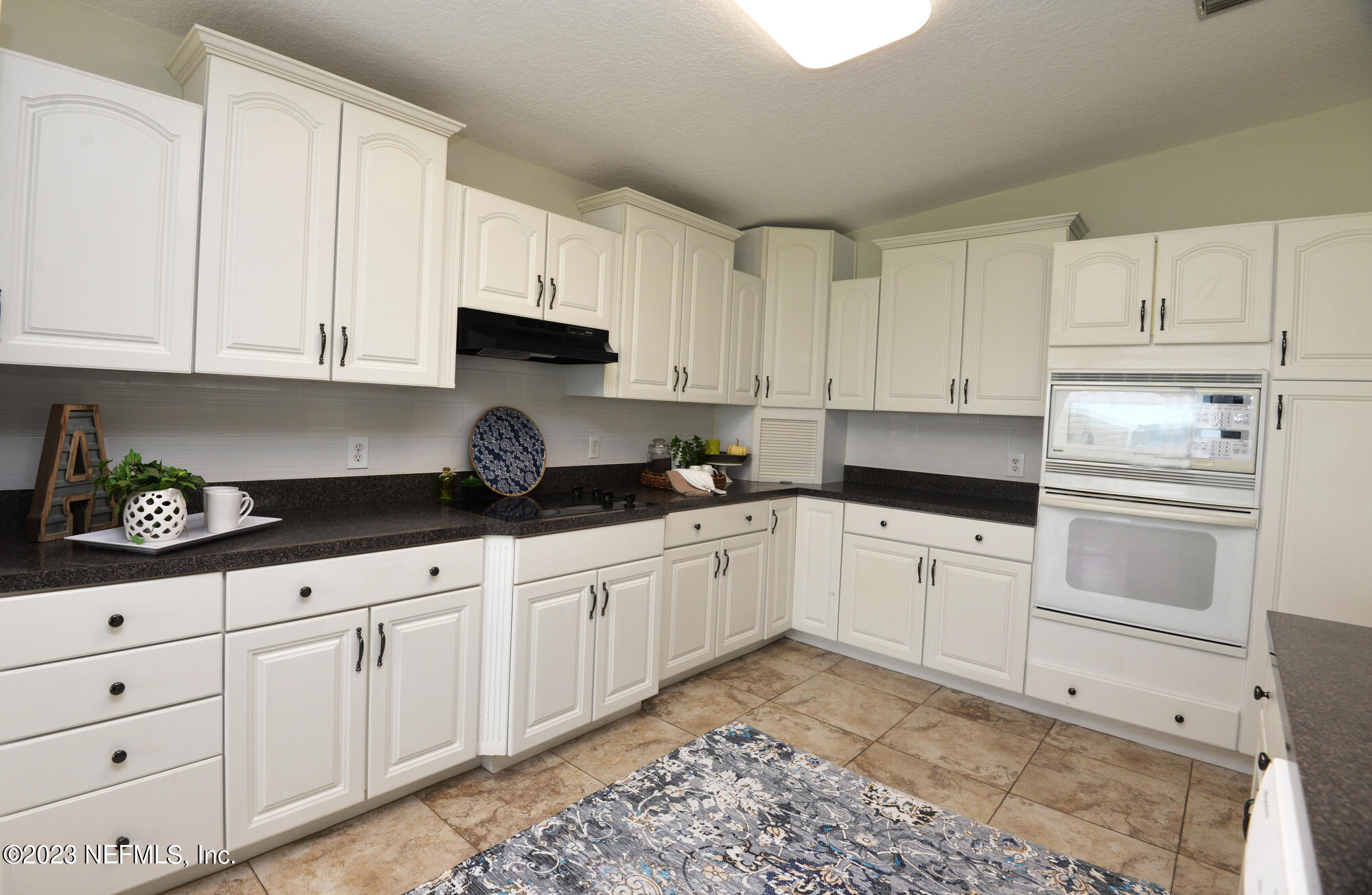 2976 Magnolia Road Orange Park, FL 32065 - Photo 14 of 44 a kitchen with granite countertop white cabinets and white appliances