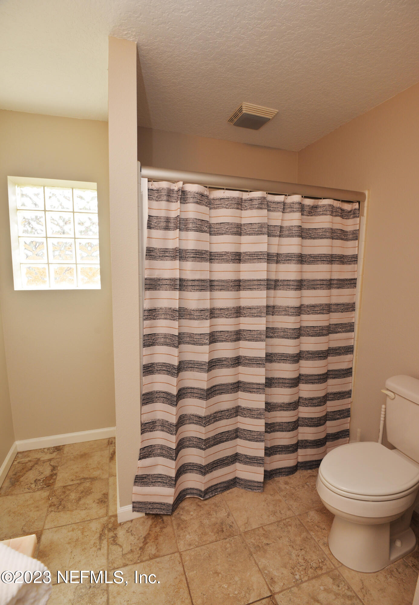 2976 Magnolia Road Orange Park, FL 32065 - Photo 27 of 44 a bathroom with a toilet and a shower curtain