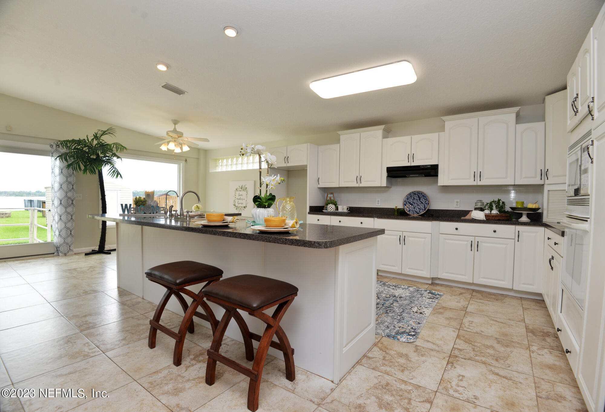 2976 Magnolia Road Orange Park, FL 32065 - Photo 10 of 44 a kitchen with stainless steel appliances granite countertop a table chairs sink refrigerator and cabinets