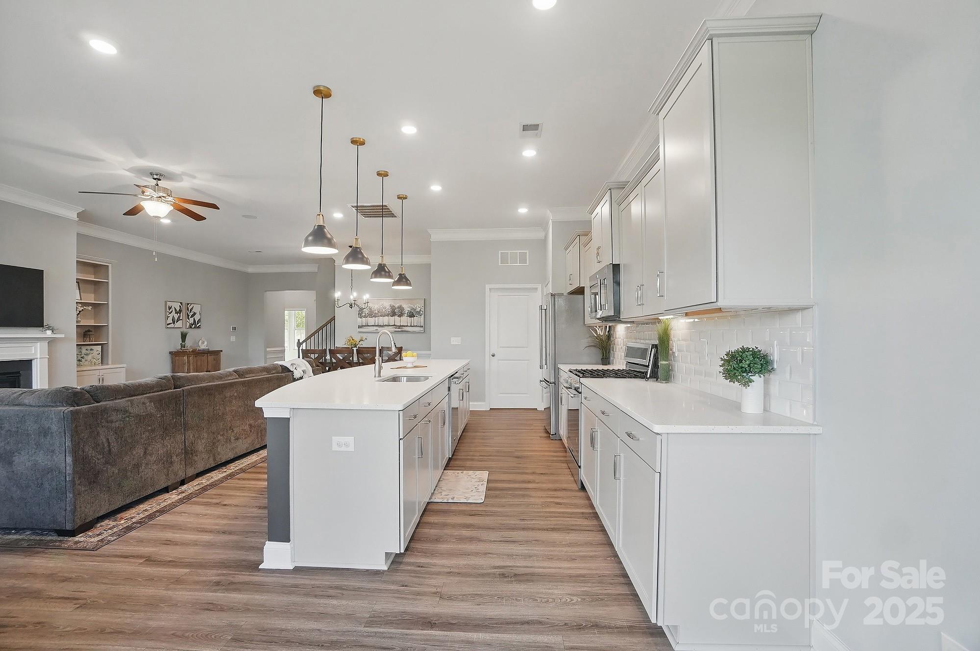 5004 Oakmere Road Waxhaw, NC 28173 - Photo 14 of 48 a large kitchen with stainless steel appliances kitchen island a large counter top and a wooden floors
