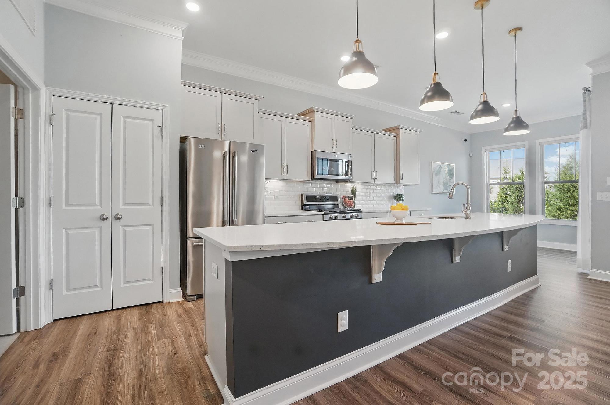 5004 Oakmere Road Waxhaw, NC 28173 - Photo 9 of 48 a kitchen with kitchen island a sink stainless steel appliances and cabinets
