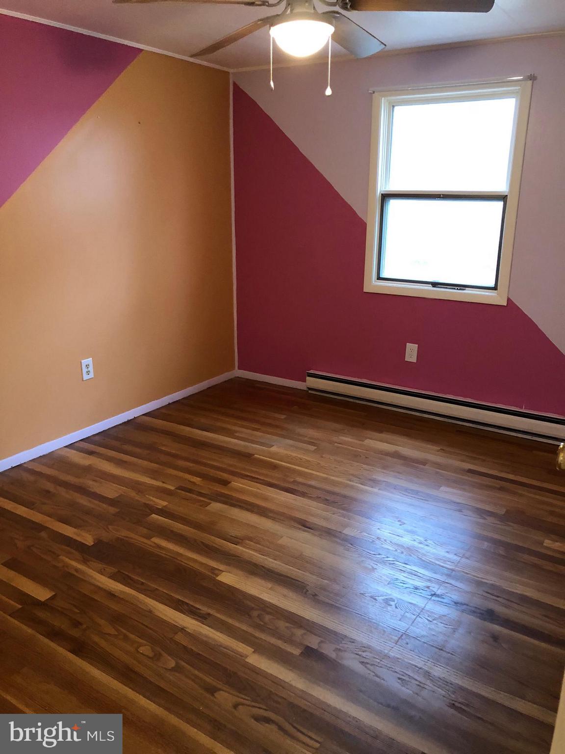 11804 Warner Road Keymar, MD 21757 - Photo 5 of 9 an empty room with wooden floor and windows