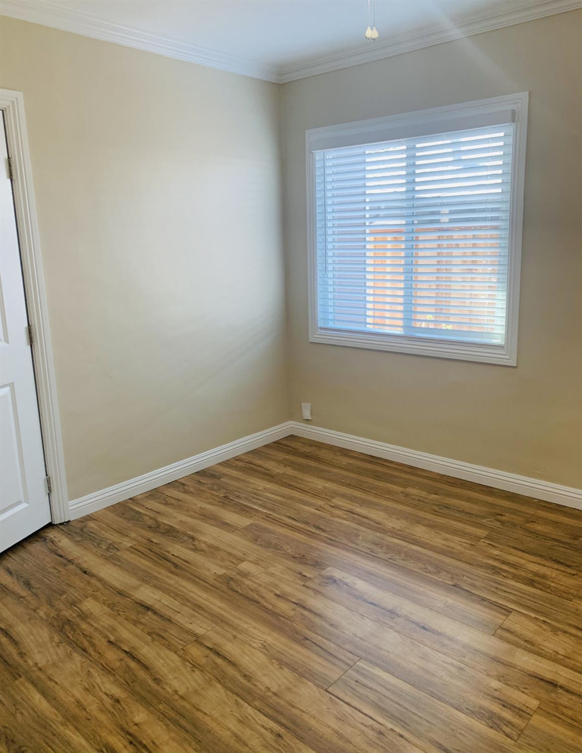 1163 Roxanne Avenue Hayward, CA 94542 - Photo 9 of 18 a view of an empty room with wooden floor and a window