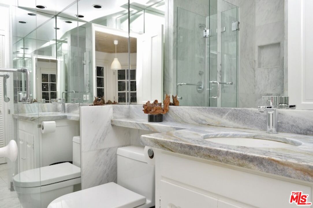 4031 Hollyline Avenue Sherman Oaks, CA 91423 - Photo 14 of 31 a bathroom with a granite countertop sink a toilet and a mirror