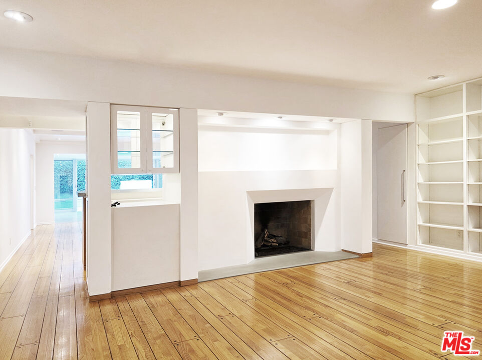 4031 Hollyline Avenue Sherman Oaks, CA 91423 - Photo 2 of 31 a view of an empty room with wooden floor and a fireplace