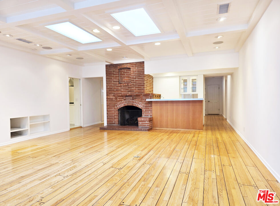 4031 Hollyline Avenue Sherman Oaks, CA 91423 - Photo 6 of 31 a view of empty room with wooden floor and fireplace