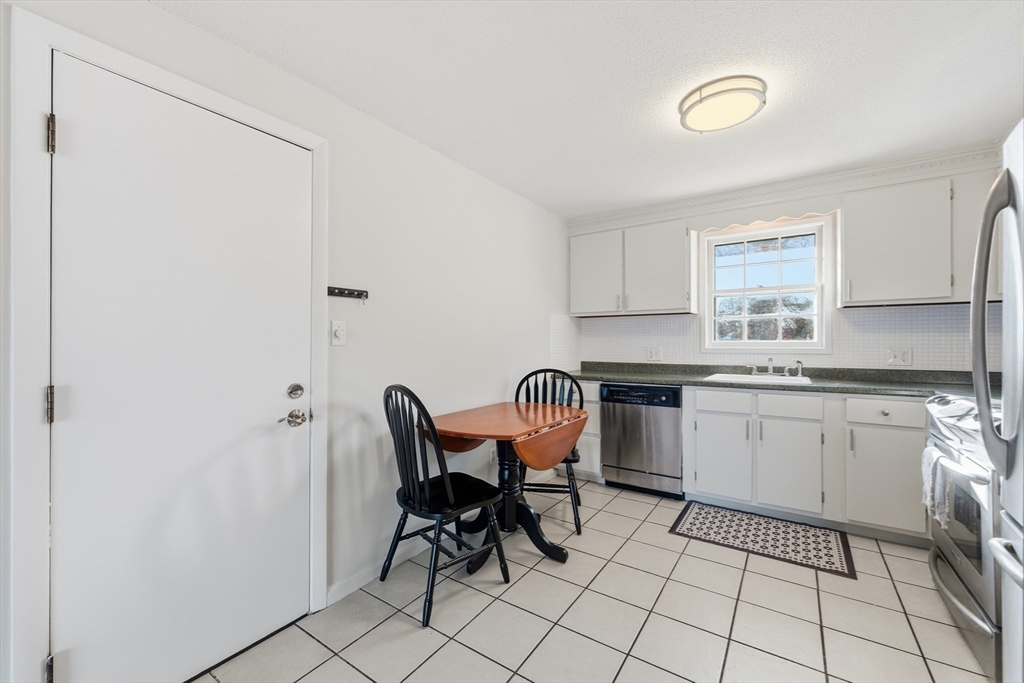 5 Pilgrim Circle, Unit C Methuen, MA 01844 - Photo 9 of 23 a kitchen with cabinets and chairs