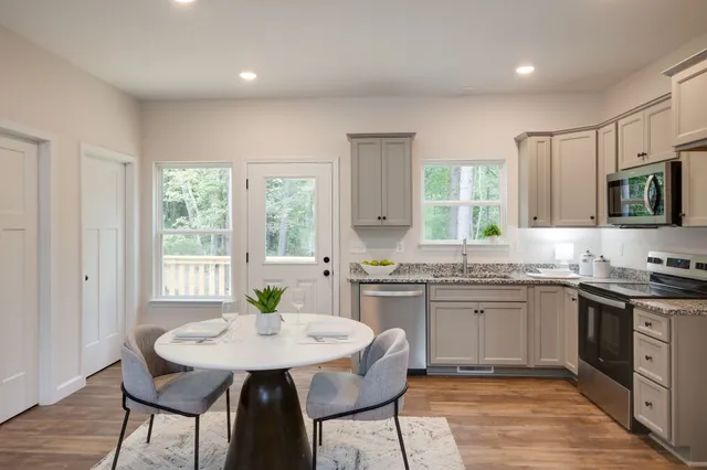 a kitchen with granite countertop sink stove and chairs