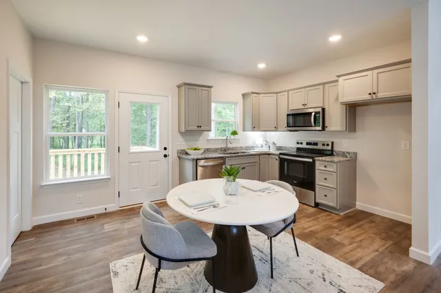 a kitchen with kitchen island a white counter top space a sink appliances and cabinets