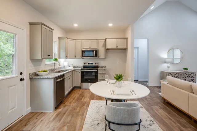 a kitchen with kitchen island a white table and chairs