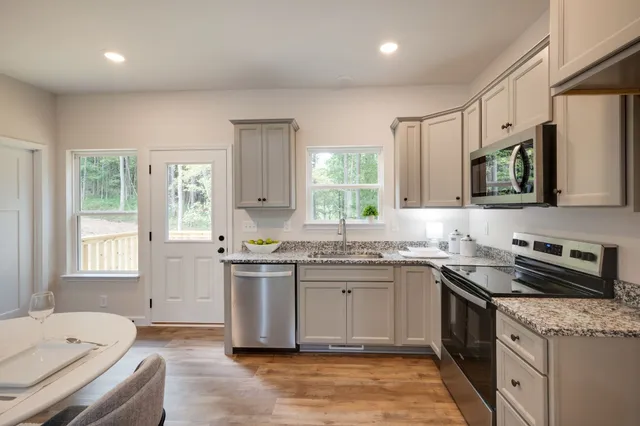 a kitchen with a sink stove top oven and refrigerator