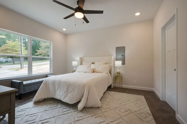 a bedroom with a bed and a large window