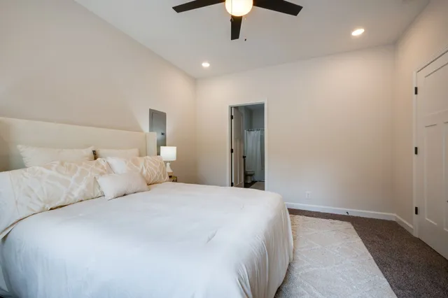 a bedroom with a large bed and a chandelier