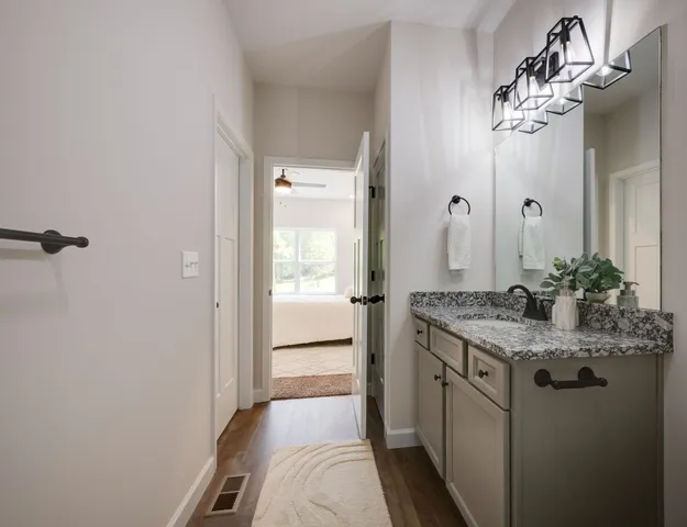 a bathroom with a granite countertop sink a mirror and a shower