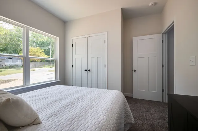a bedroom with a bed and a large window
