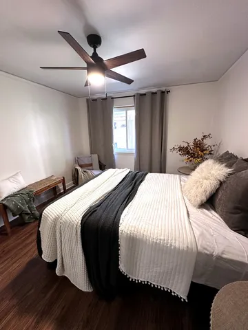a bedroom with a bed and wooden floor