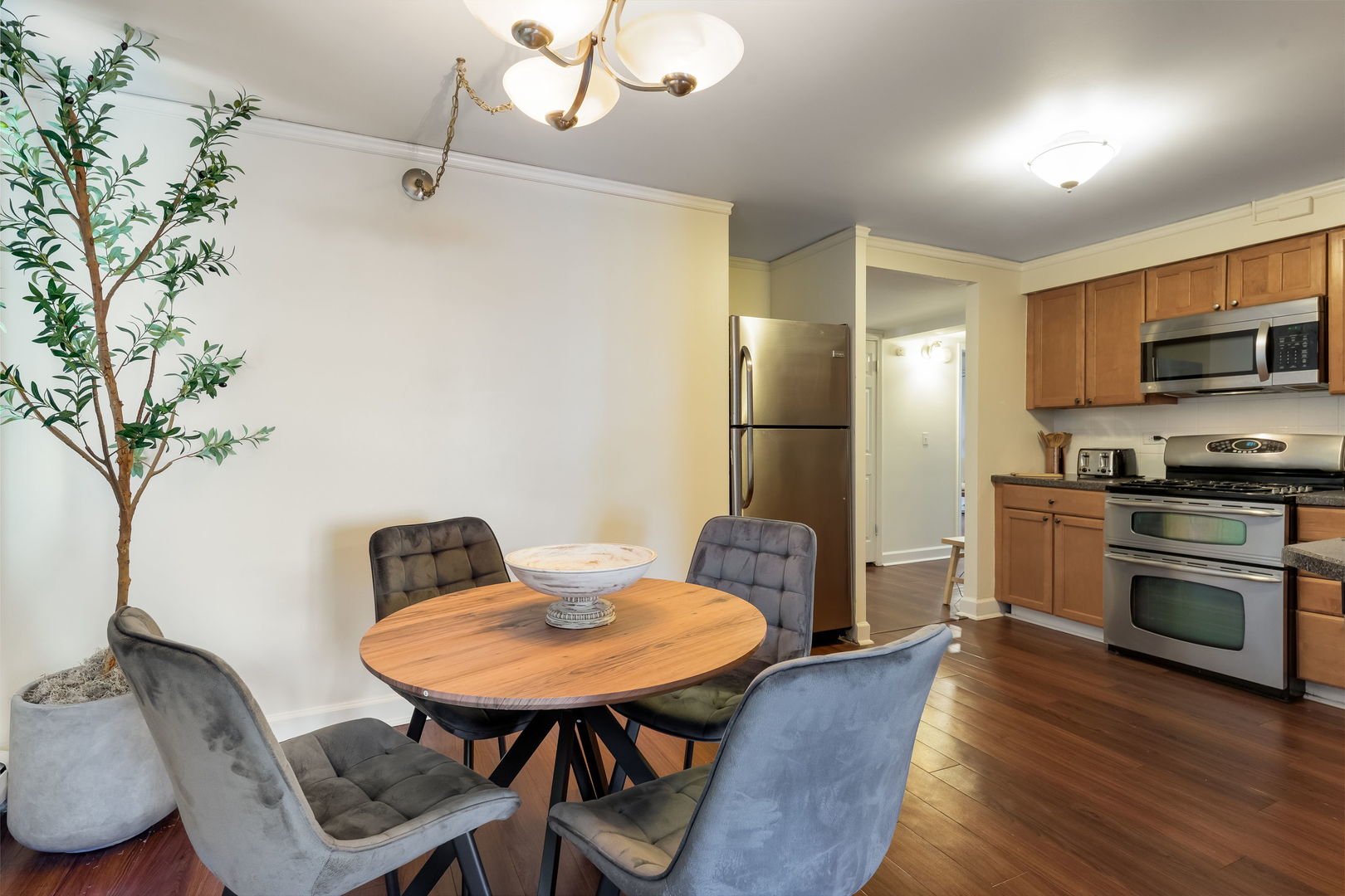 5543 West Higgins Avenue, Unit 1 Chicago, IL 60630 - Photo 10 of 21 a kitchen with stainless steel appliances kitchen island granite countertop a table chairs a refrigerator and a stove