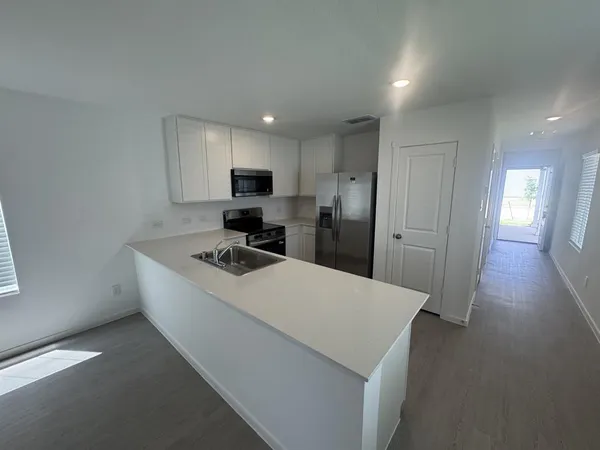 a kitchen with a refrigerator a stove top oven a sink and a refrigerator