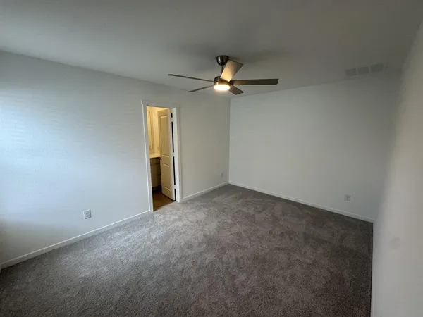 an empty room with closet and a chandelier fan