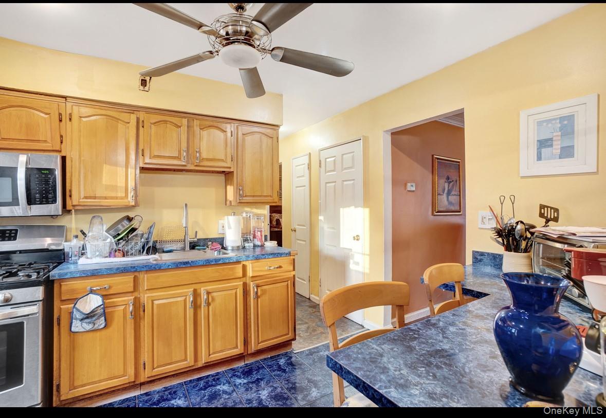 1024 Mahopac Road West Hempstead, NY 11552 - Photo 12 of 25 a kitchen with a stove a refrigerator and cabinets