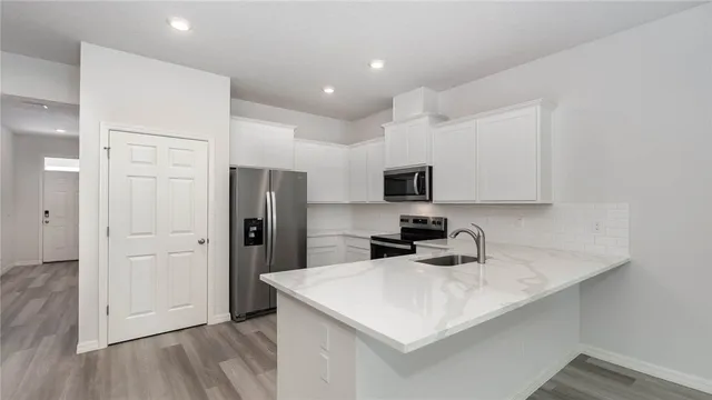a kitchen with a sink a stove a refrigerator and cabinets