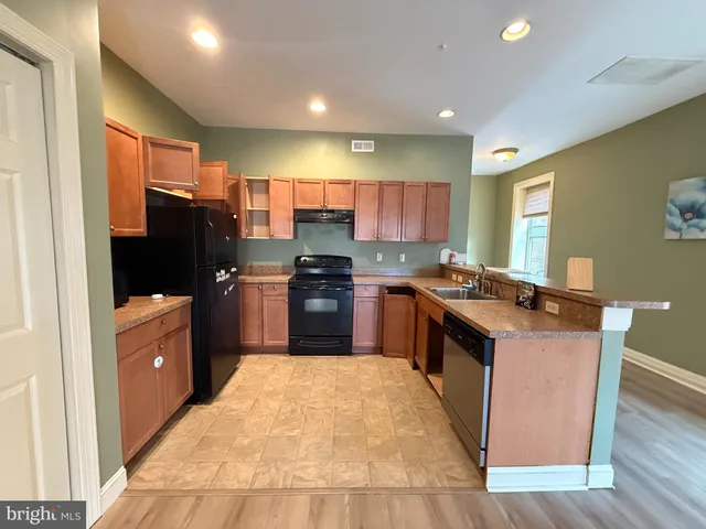 a kitchen with stainless steel appliances granite countertop a stove top oven a sink dishwasher a refrigerator and a refrigerator