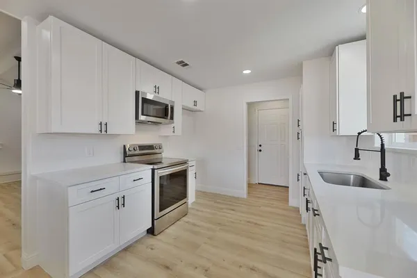 a kitchen with stainless steel appliances granite countertop a sink stove and refrigerator